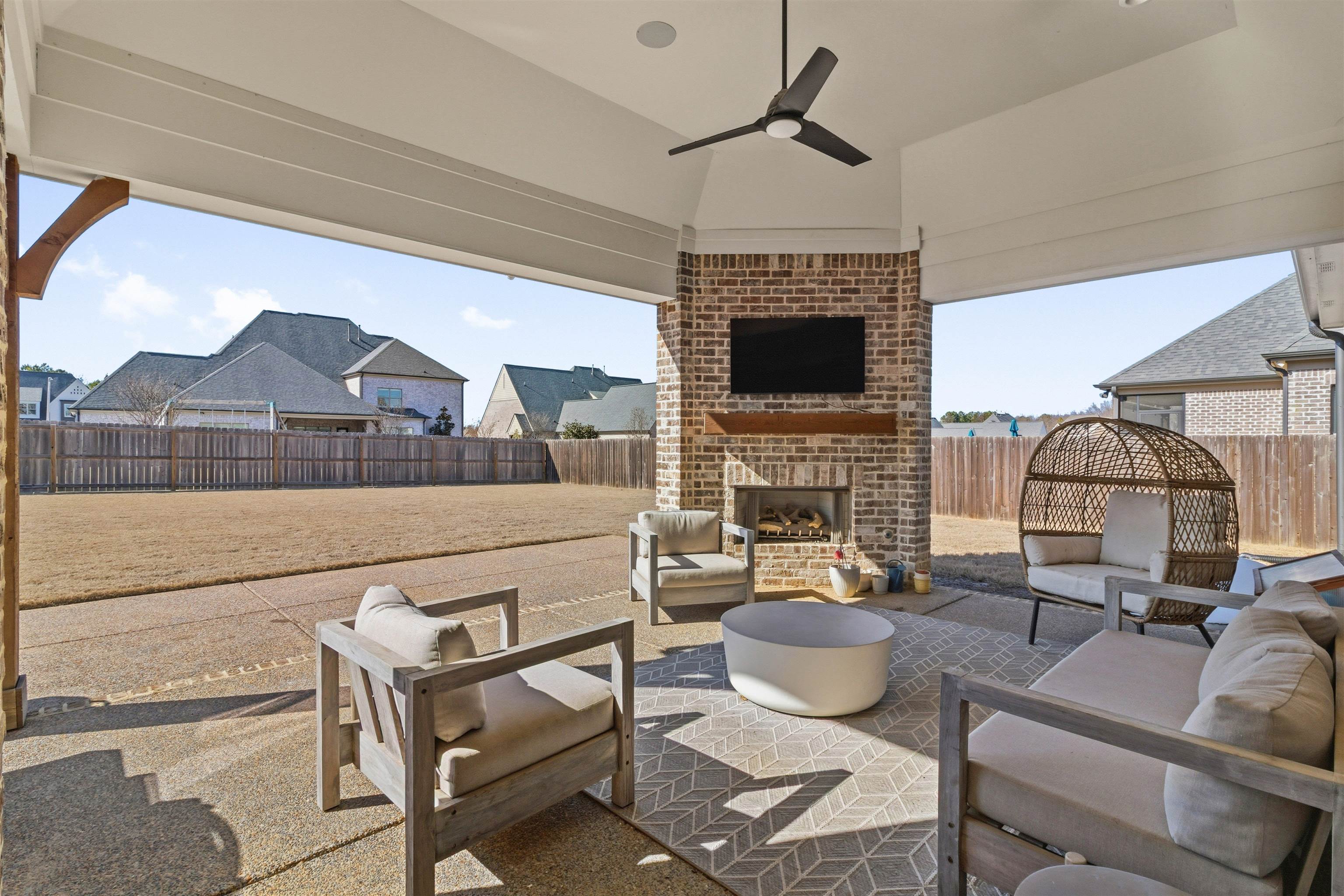 4757 Carousel Lane Collierville, TN 38017 - Photo 35 of 39 Fenced backyard with ceiling fan, a patio, and an outdoor living space with a fireplace
