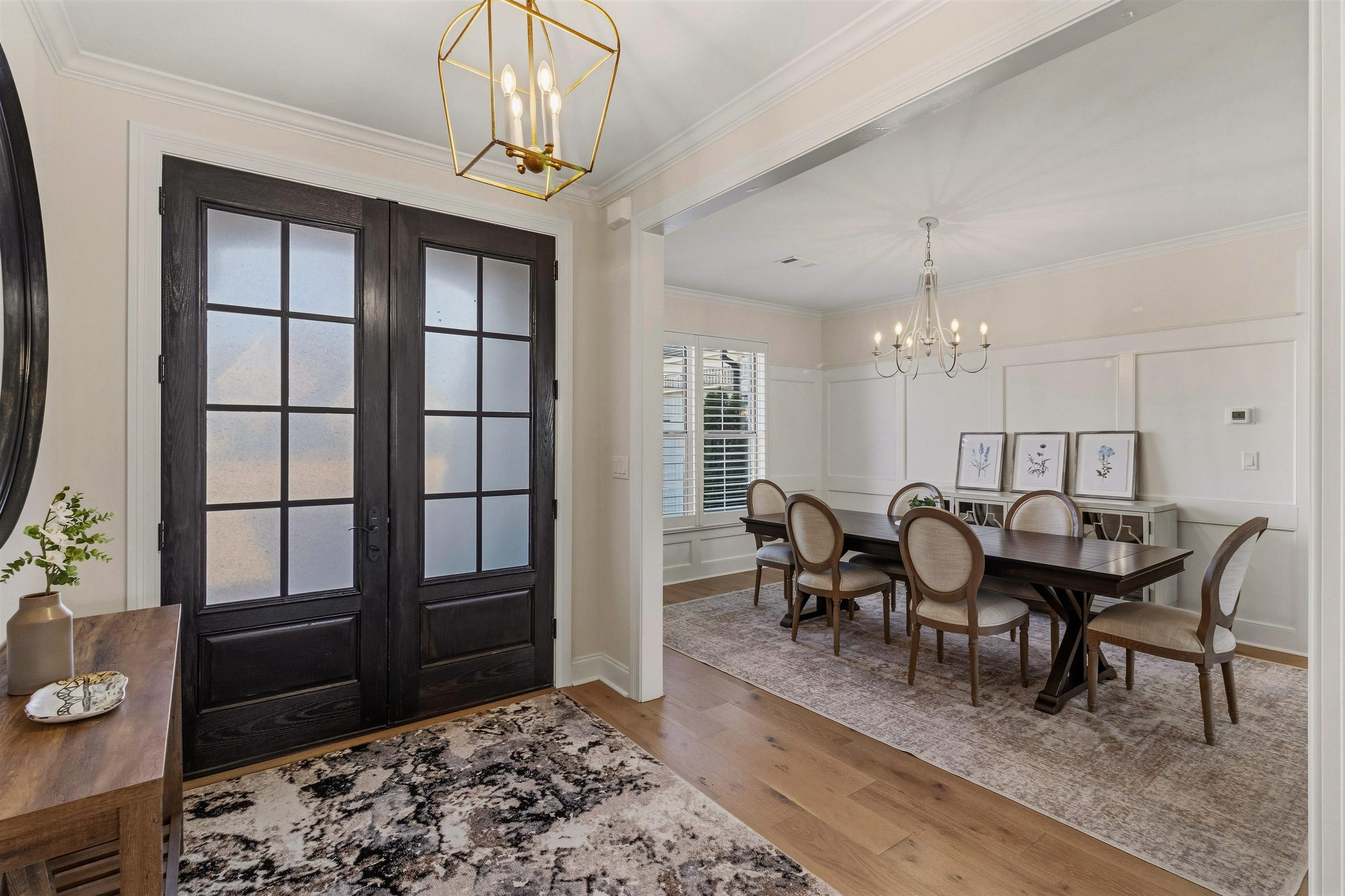4757 Carousel Lane Collierville, TN 38017 - Photo 5 of 39 Foyer entrance featuring hanging lights, a decorative wall, light wood-type flooring, crown molding, and french doors