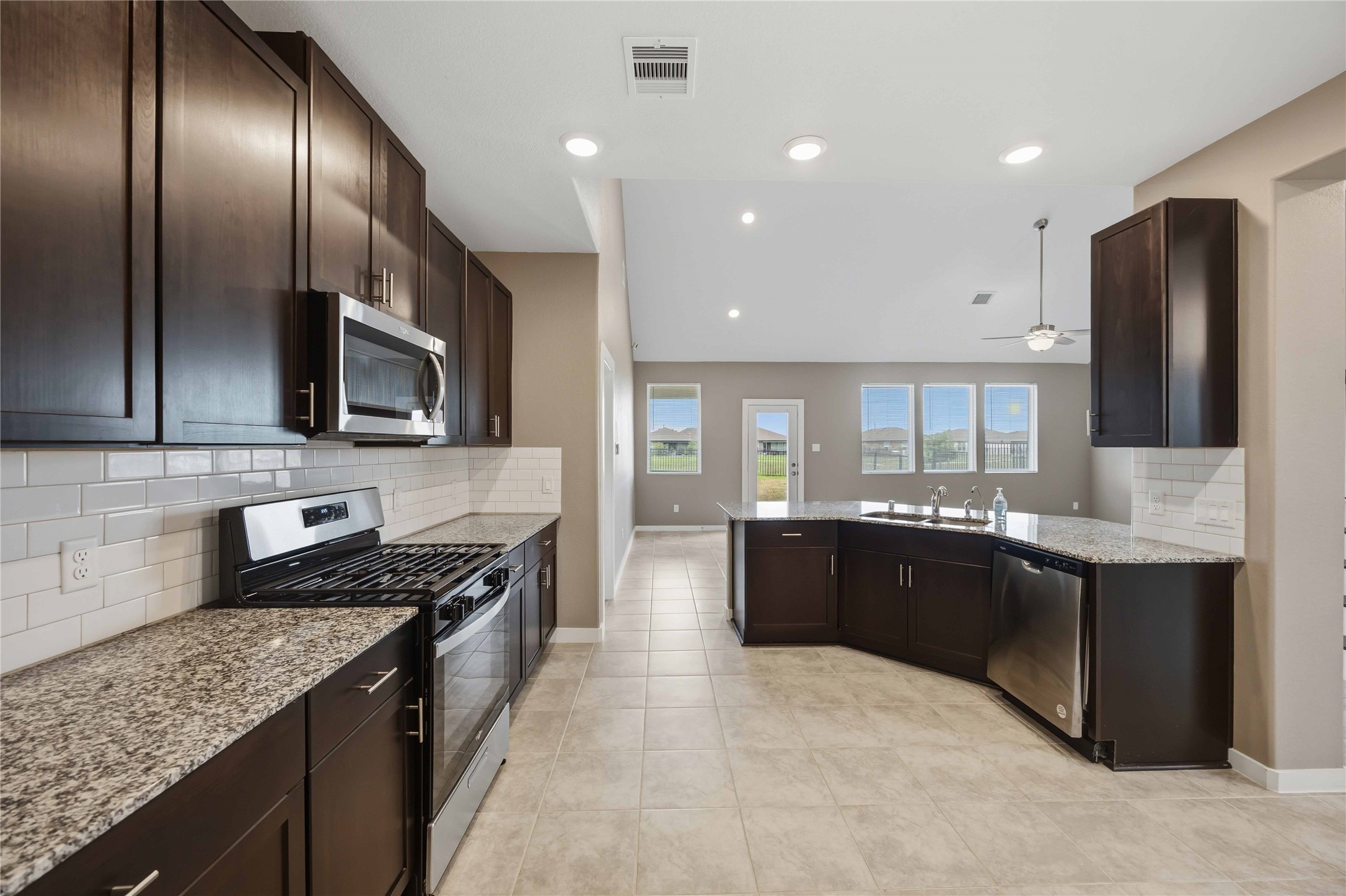 1239 Cascade Hls Drive Rosharon, TX 77583 - Photo 12 of 30 a large kitchen with stainless steel appliances granite countertop a stove a sink and a microwave