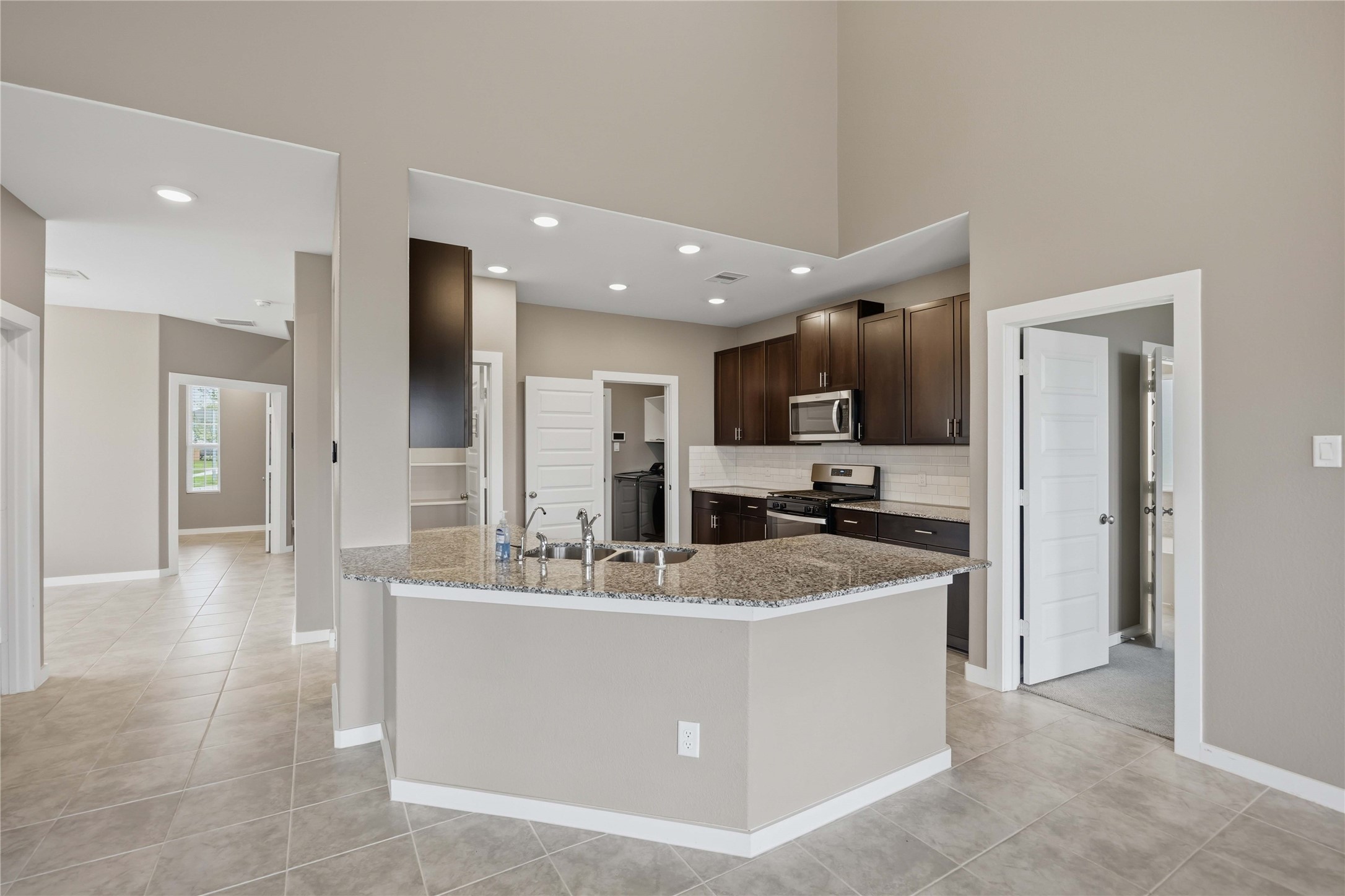 1239 Cascade Hls Drive Rosharon, TX 77583 - Photo 10 of 30 a large kitchen with stainless steel appliances kitchen island a stove a refrigerator a sink dishwasher with a dining table and chairs
