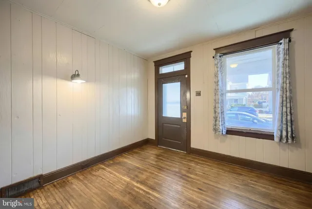 a view of an empty room with window and wooden floor