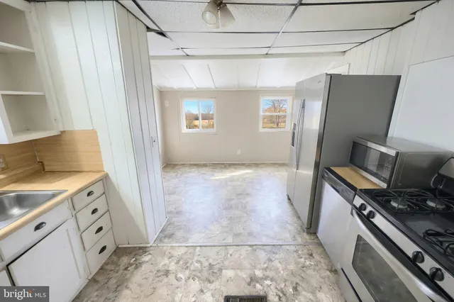 a kitchen with stainless steel appliances granite countertop a refrigerator a stove and a sink