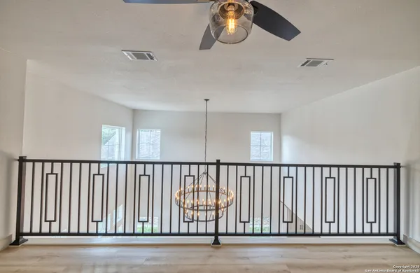 a view of staircase with railing and a ceiling fan