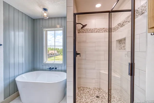 a white bath tub sitting next to a shower