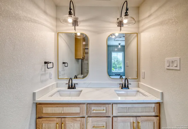 a bathroom with double vanity sinks and a mirror