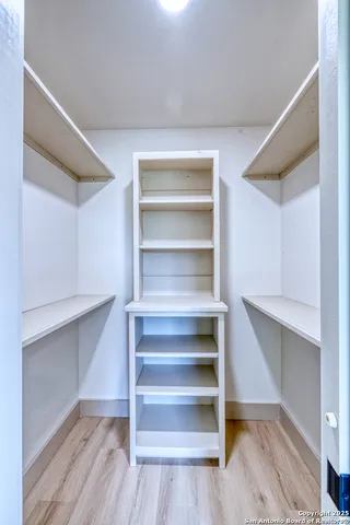 a view of walk in closet with empty racks
