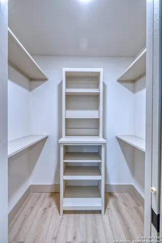 a view of walk in closet with wooden floor