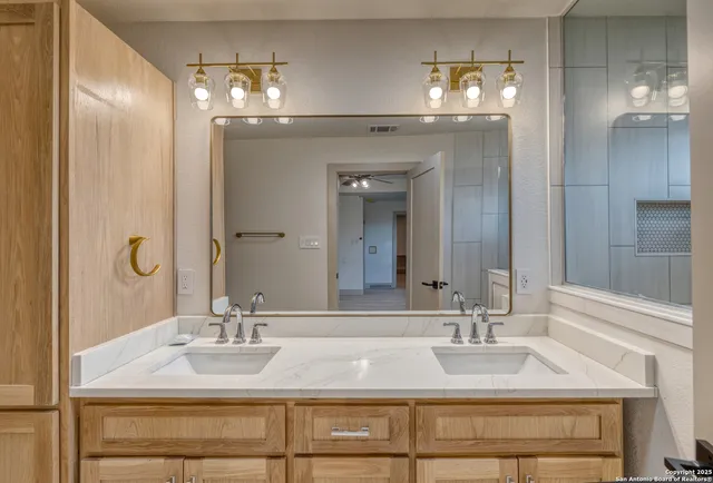 a bathroom with double vanity sinks and a mirror