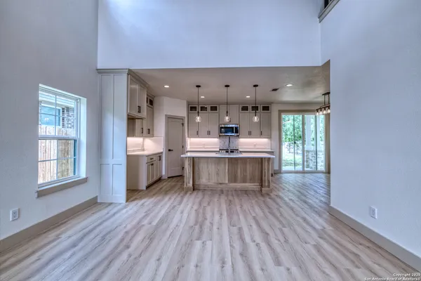 a kitchen with stainless steel appliances kitchen island wooden floors and view living room