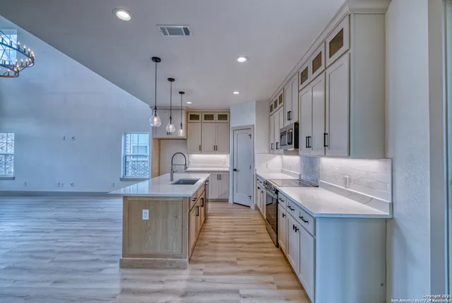 a kitchen with stainless steel appliances granite countertop a sink stove and wooden floor