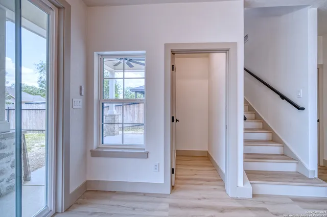 a view of a hallway with wooden floor and entryway