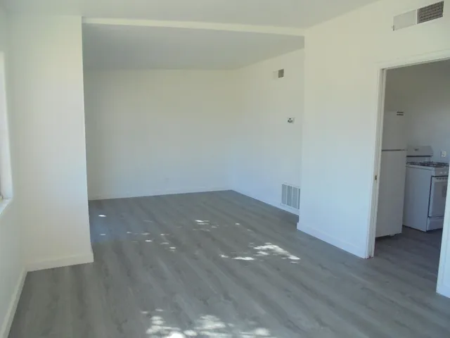 a view of empty room with wooden floor