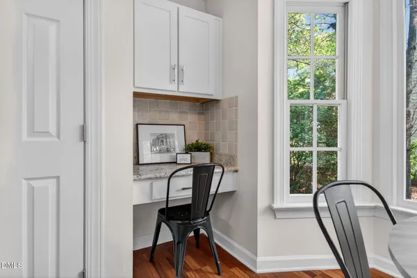 a view of a workspace with furniture and a window