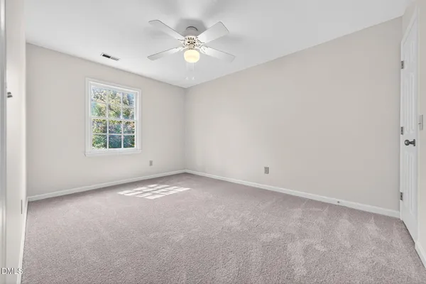 a bedroom with a bed and a chandelier next to a window