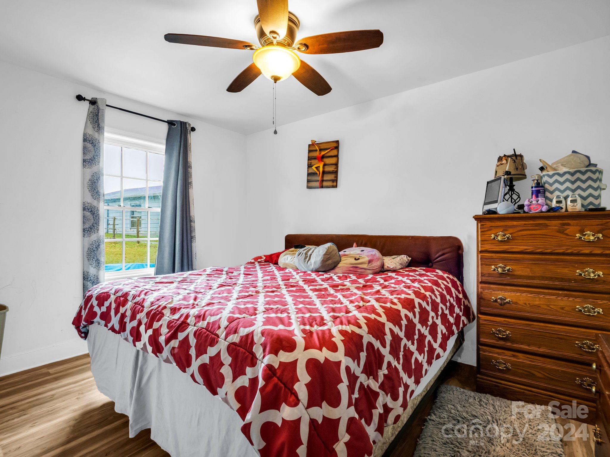 1251 Howards Creek Mill Road Vale, NC 28168 - Photo 12 of 30 a bedroom with a bed and a chandelier