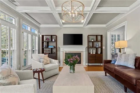 a living room with furniture a fireplace and a chandelier