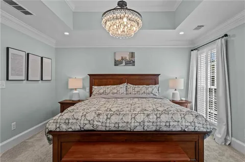 a bedroom with a large bed and a chandelier