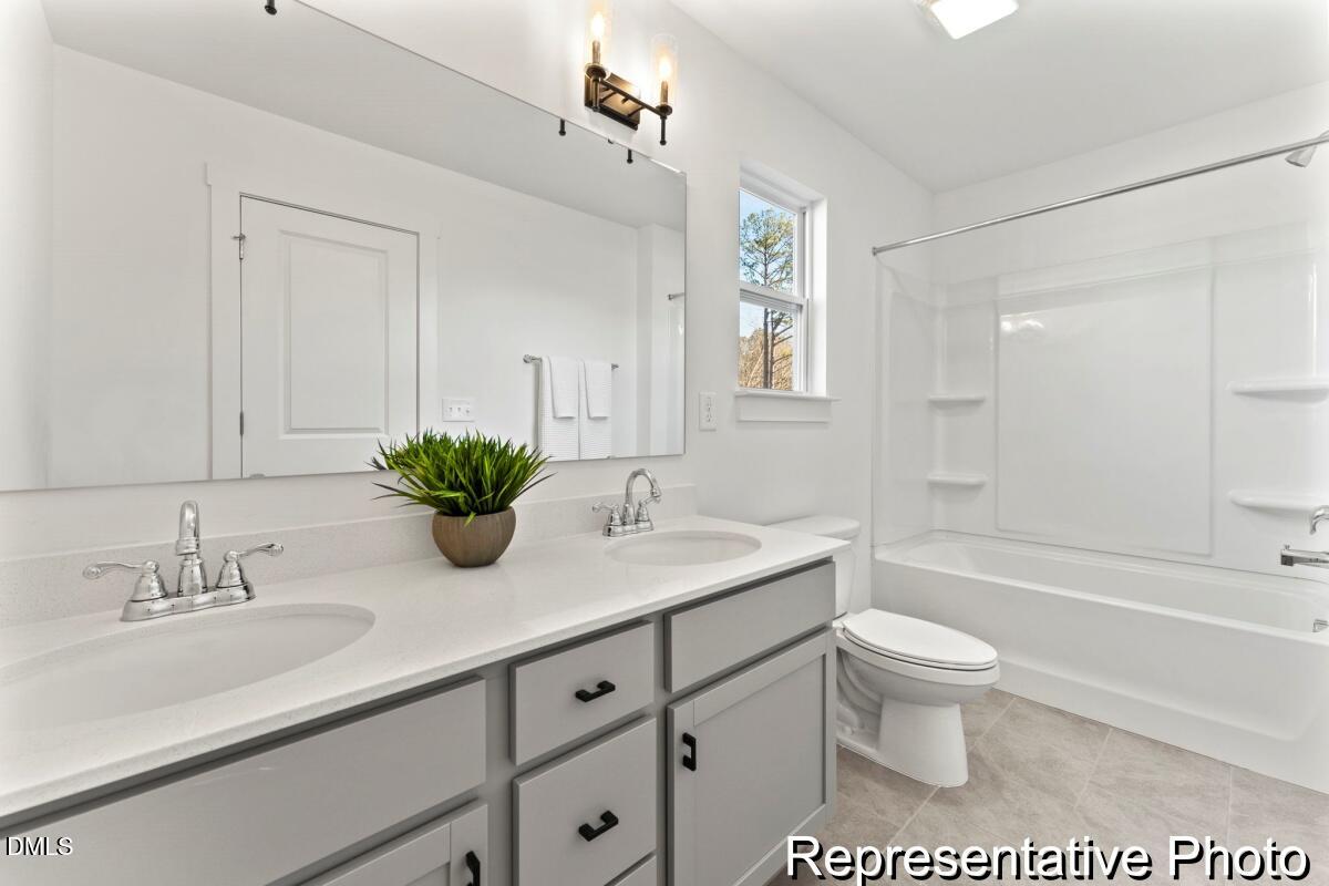 105 Cedarbranch Way, Unit 183P Dunn, NC 28334 - Photo 18 of 24 a bathroom with a sink a toilet and a bathtub