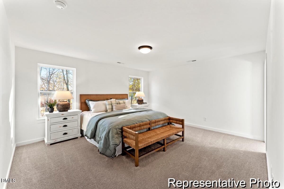 105 Cedarbranch Way, Unit 183P Dunn, NC 28334 - Photo 20 of 24 a spacious bedroom with a bed and a window