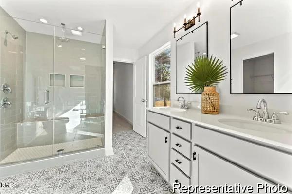 a bathroom with a double vanity sink mirror and shower
