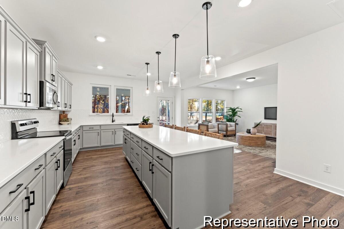 105 Cedarbranch Way, Unit 183P Dunn, NC 28334 - Photo 7 of 24 a large kitchen with kitchen island a sink a counter top space appliances and cabinets