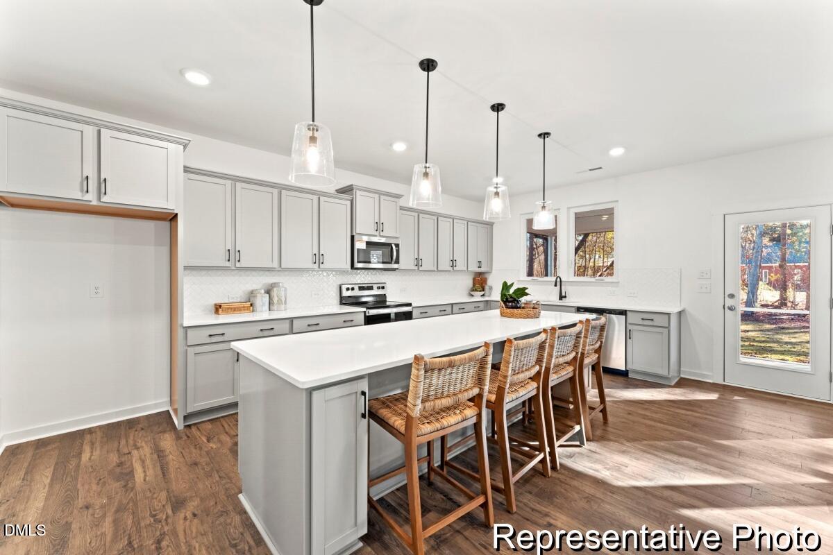 105 Cedarbranch Way, Unit 183P Dunn, NC 28334 - Photo 8 of 24 a kitchen with stainless steel appliances kitchen island granite countertop a table chairs and a refrigerator