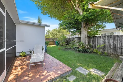a view of a chair and table in backyard of the house