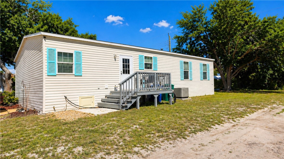 324 Valencia Street Sebastian, FL 32958 - Photo 1 of 21 a front view of house with yard and trees in the background