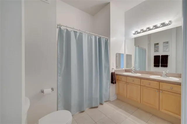 a spacious bathroom with a double vanity sink and a mirror