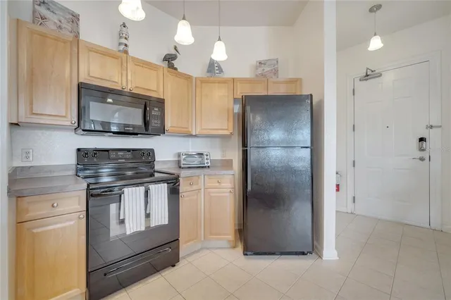 a kitchen with stainless steel appliances granite countertop a refrigerator a stove a sink and a microwave