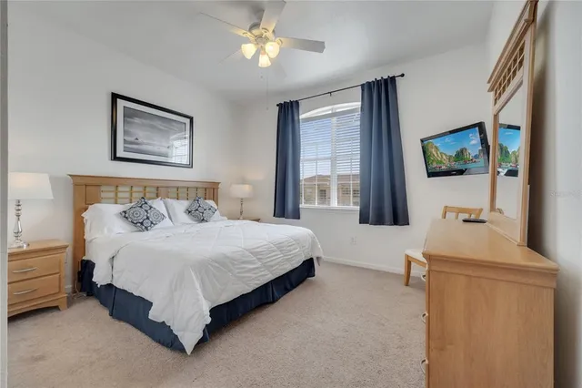 a bedroom with a bed a window and a flat screen television