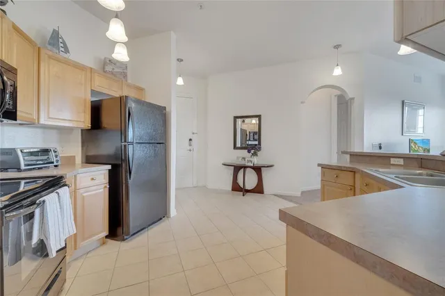 a kitchen with stainless steel appliances granite countertop a refrigerator a sink and a stove