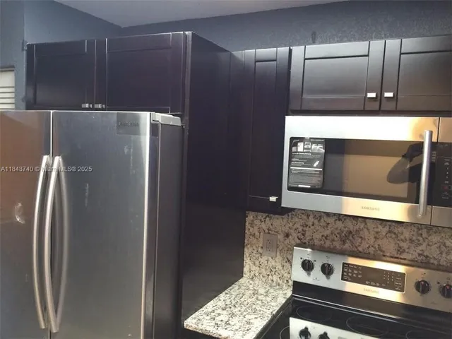a metallic refrigerator freezer sitting in a kitchen