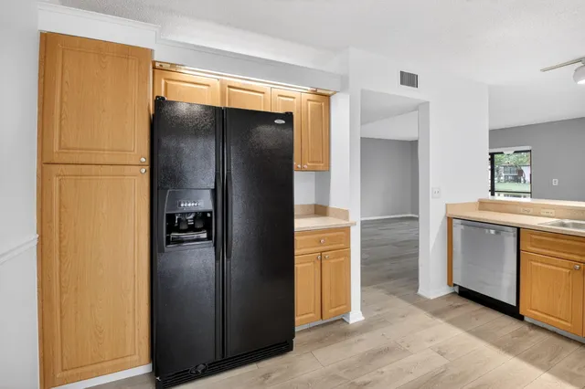 a kitchen with white cabinets and refrigerator