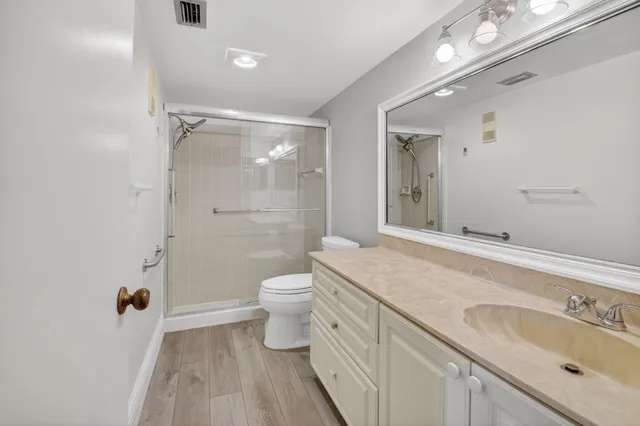 a bathroom with a sink a toilet and shower