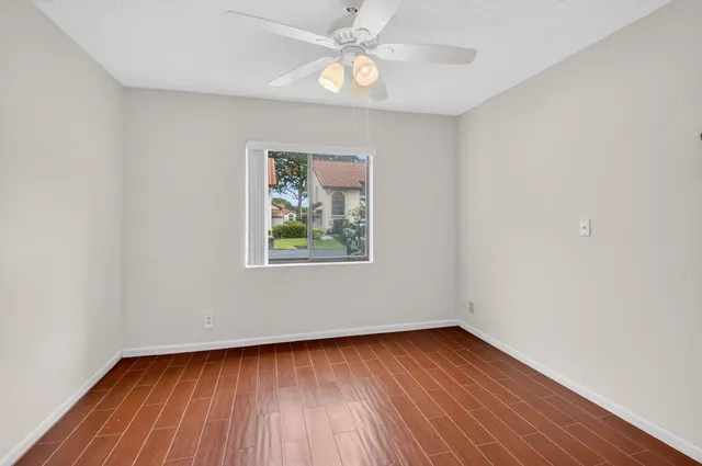 an empty room with a window and wooden floor