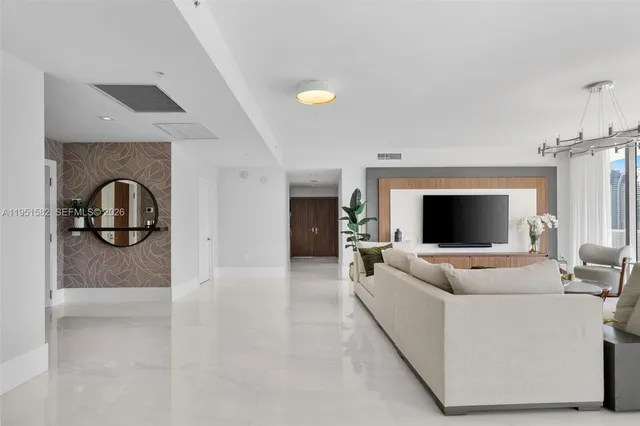 a living room with furniture fireplace and a large window