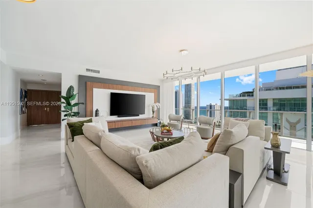 a living room with furniture a flat screen tv and a fireplace