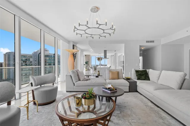 a view of a kitchen with kitchen island a large window a sink and stainless steel appliances