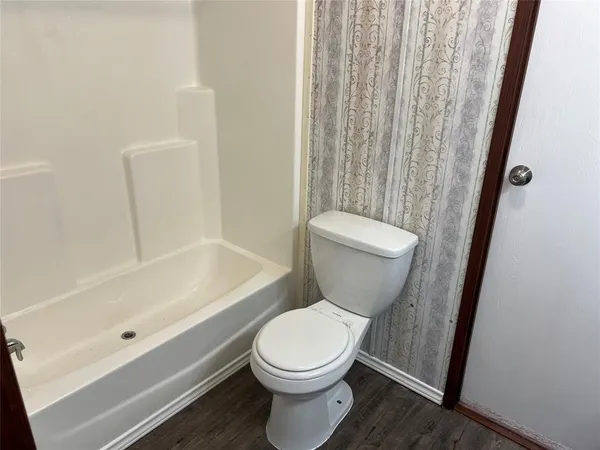 a white toilet sitting next to a bath tub