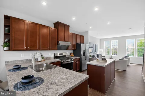 a kitchen with sink refrigerator dining table and chairs