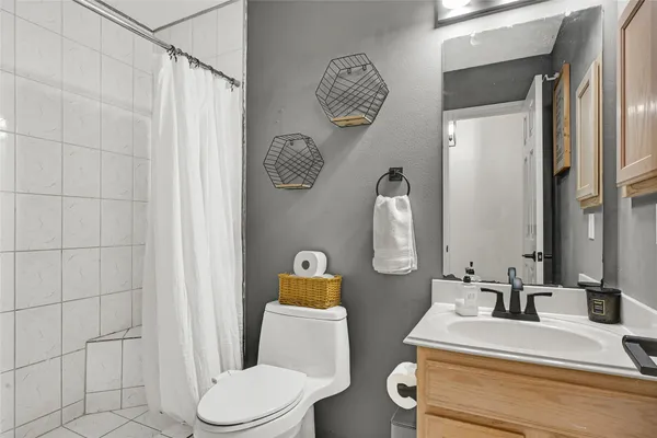a bathroom with a sink vanity mirror and toilet