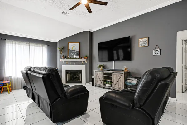 a living room with furniture a flat screen tv and a fireplace
