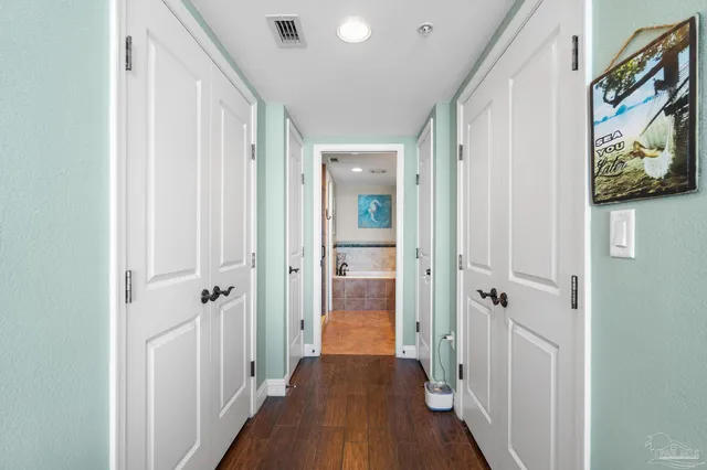 a view of a hallway with wooden floor and closet