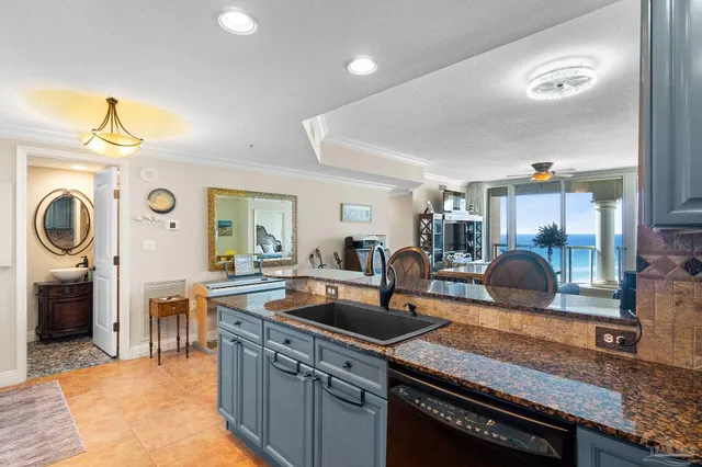 a kitchen with stainless steel appliances granite countertop a sink a stove and a wooden floors