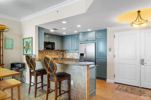 a view of kitchen with refrigerator stove dining table and chairs