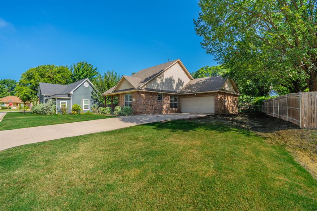 403 Summer Tree Lane Springtown, TX 76082 - Photo 14 of 19 Brick exterior with an attached garage, landscaping, and a fenced yard