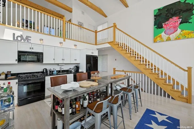 a open kitchen with stainless steel appliances kitchen island granite countertop a stove a chimney a dining table and chairs