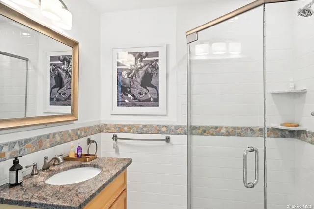 a bathroom with a granite countertop sink and a mirror