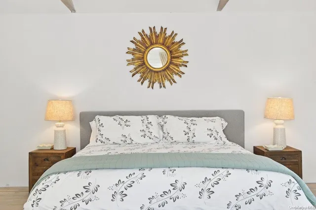 a bedroom with a bed and a lamp on dresser